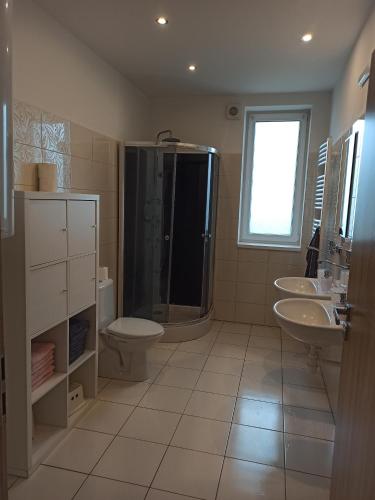 a bathroom with two sinks a toilet and a shower at Holiday House Adrelot in Heřmaničky