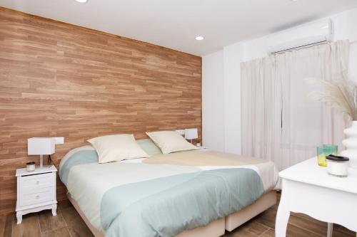 a bedroom with a bed and a wooden wall at El Hortal i lloo in El Cuervo