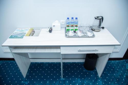 a white desk with bottled water and drinks on it at Lola Kokand Hotel in Kokand