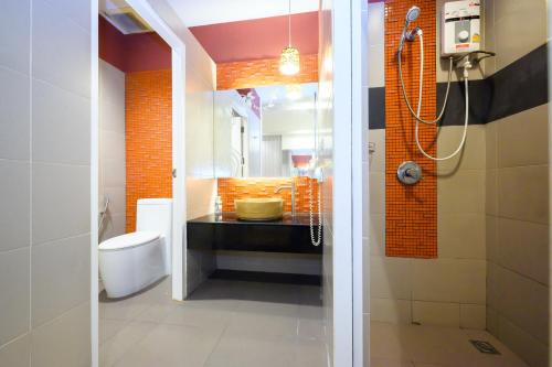 a bathroom with a shower and a sink and a toilet at Ruen Rattana Resort in Nonthaburi
