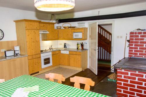 Steinfeld的住宿－Drautal Alm Schönbuch，厨房配有木制橱柜和桌椅