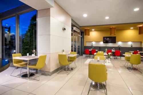 a restaurant with yellow and red chairs and tables at Ibis Kayseri in Kayseri