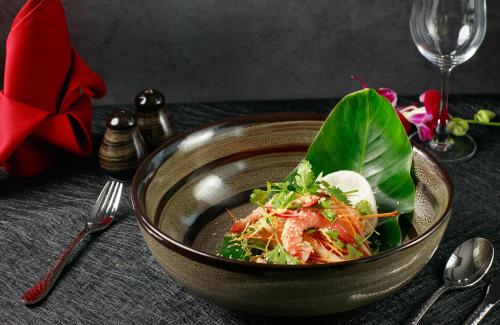 a bowl of salad with shrimp and greens on a table at Hermes Cruises in Ha Long