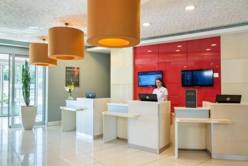 a woman standing at a counter in an office lobby at Ibis Kayseri in Kayseri