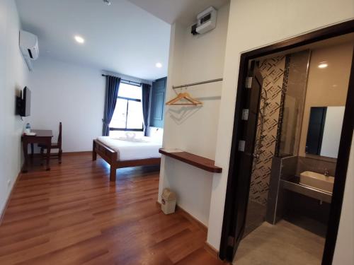 Zimmer mit einem Schlafzimmer mit einem Bett und einem Bad in der Unterkunft โรงแรมรชาโขง Racha Khong Hotel in Nakhon Phanom