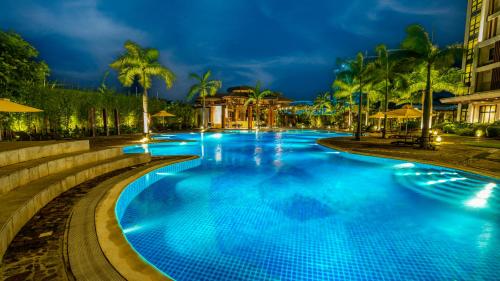 a large swimming pool with blue water at night at The Bayleaf Cavite in General Trias