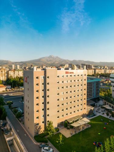 a large white building with a lawn in front of it at Ibis Kayseri in Kayseri