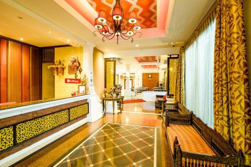 a lobby with benches and a chandelier at Ruen Rattana Resort in Nonthaburi