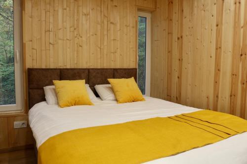 Un dormitorio con una cama grande con almohadas amarillas. en Shavit Village Glamping, en Akhatani