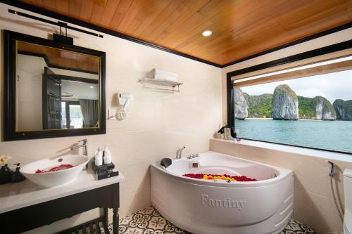baño con bañera, lavabo y ventana en Hermes Cruises, en Ha Long