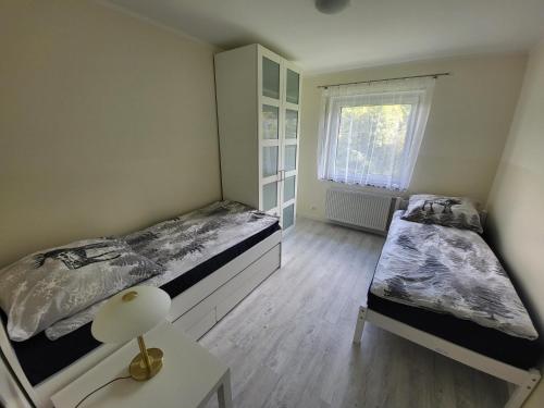 Hilders的住宿－Ferienwohnung Wenzel，一间卧室设有两张床、一张桌子和一个窗口