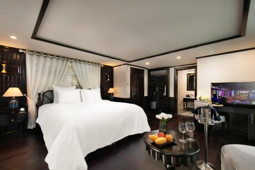 a bedroom with a large white bed and a tv at Hermes Cruises in Ha Long