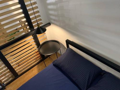 um quarto com uma cama, uma cadeira e uma janela em JORA LOFT- modern industrial apartment 1-A em Dagupan