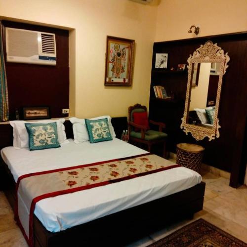um quarto com uma cama grande e um espelho em Inayat Villa em Udaipur