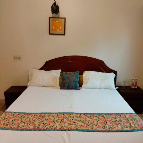 um quarto com uma cama grande e uma cabeceira em madeira em Inayat Villa em Udaipur