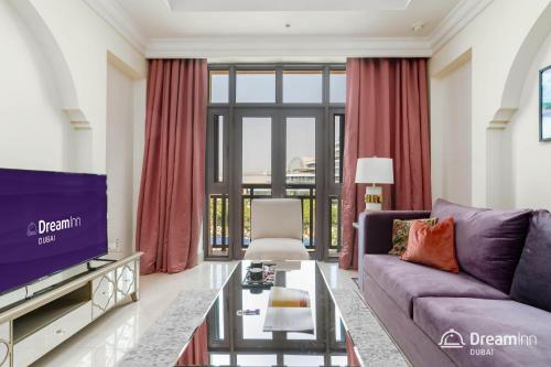 a living room with a purple couch and a tv at Dream Inn Apartment- Tajer Souk Al Bahar in Dubai