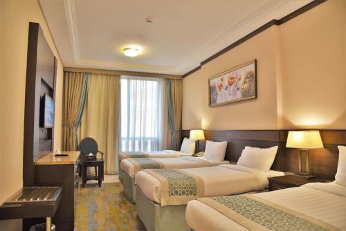 Una cama o camas en una habitación de Afraa Hotel Al Aziziya