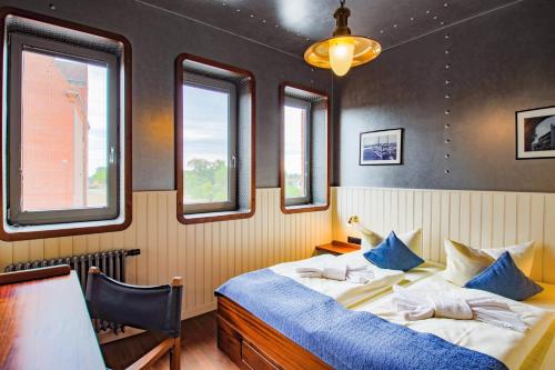 a bedroom with two beds and two windows at Hotel Dömitzer Hafen in Dömitz