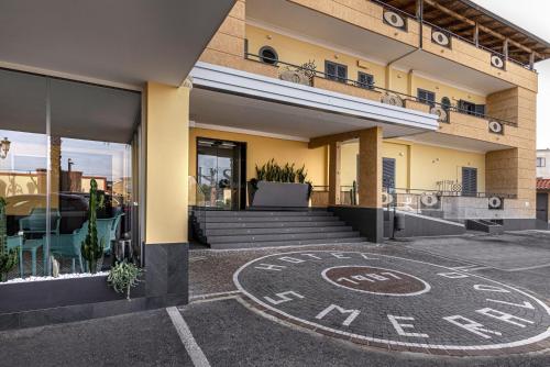 a building with a sign on the ground in front of it at Hotel Smeraldo in Qualiano