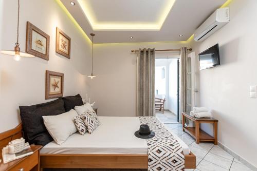 a living room with a bed and a tv at Hotel Palatia in Naxos Chora