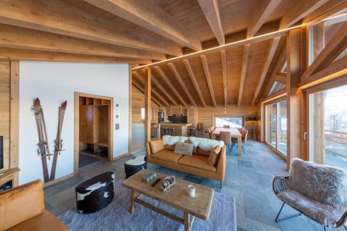 a living room with a couch and a table at Oak Tree Chalet - on the ski slope - luxury! in Nendaz