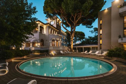 a swimming pool in front of a building at Hotel De La Ville in Riccione