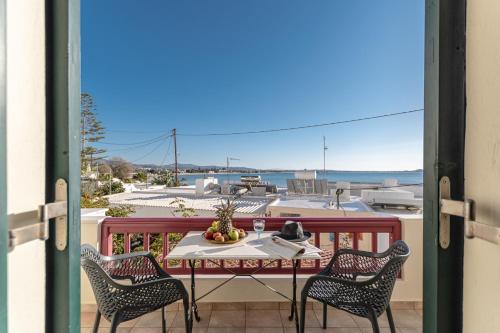 a table and chairs on a balcony with a view of the ocean at Hotel Palatia in Naxos Chora