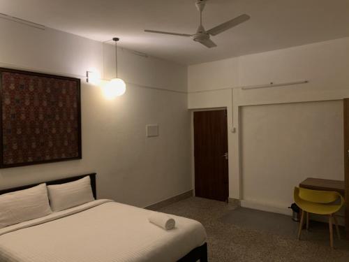 a bedroom with a bed and a table and a ceiling fan at Casilda By The Oaks Inn in Ernakulam