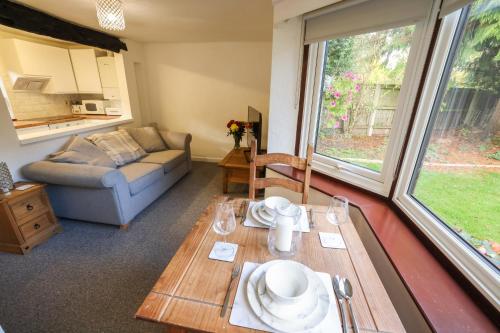 a living room with a table and a couch at The Cottage On the Common in Tenbury