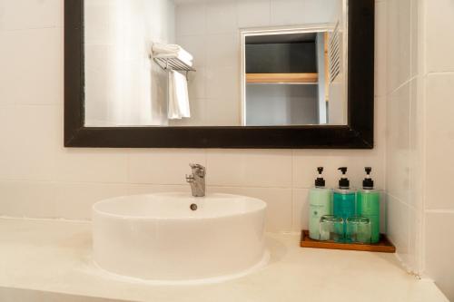 a white sink in a bathroom with a mirror at Get Zleep Premium Budget Hotel in Chiang Mai