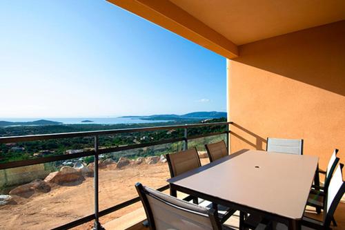 una mesa y sillas en un balcón con vistas en Via Mare en Sainte-Lucie de Porto-Vecchio