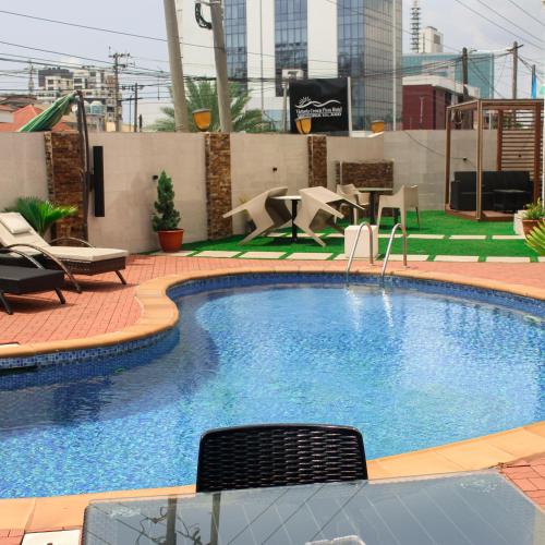 a large swimming pool with chairs and a table at Victoria Crown Plaza Hotel in Lagos