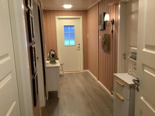 a hallway with a white door and a window at Torill`s Apartment in Kragerø