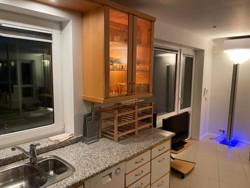 een keuken met een wastafel en een tv. bij R.R. Liepaja Apartments Siguldas in Liepāja