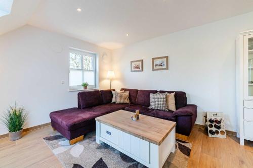 uma sala de estar com um sofá roxo e uma mesa de centro em Albatros OG em Greetsiel