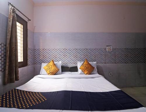 ein Schlafzimmer mit einem großen Bett mit gelben Kissen in der Unterkunft Hotel Shri Ram Residency, Sonipat, Haryana in Sonīpat