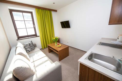 a living room with a couch and a sink at Wellness Hotel Kempa in Jablunkov