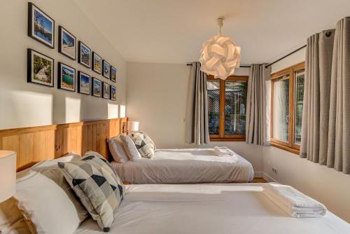 une chambre avec deux lits et un lustre dans l'établissement BIOLAY 2 - Alpes Travel - Central Chamonix - Sleeps 4-6, à Chamonix-Mont-Blanc