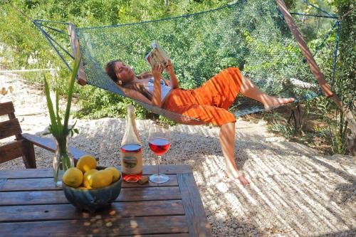 a man laying in a hammock reading a book at Carmey Avdat Farm in Midreshet Ben Gurion