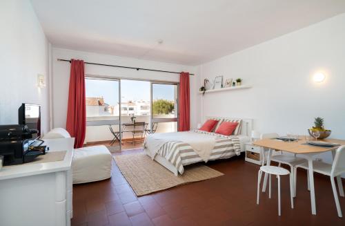 een woonkamer met een bed, een tafel en een bank bij SILCHORO - Estúdio remodelado com AC e piscina em Albufeira in Albufeira