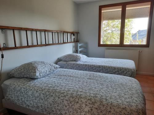two twin beds in a room with a window at La Muchette, maison au calme 3 chambres 2 salles d'eau in Juvigny
