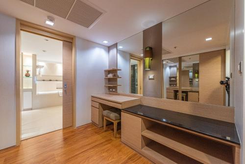 a bathroom with a sink and a mirror at Summit Windmill Golf Suite Hotel at Suvarnabhumi in Bangna
