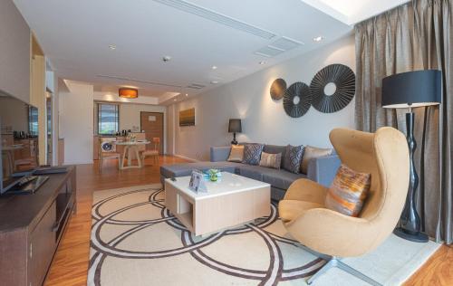 a living room with a couch and a table at Summit Windmill Golf Suite Hotel at Suvarnabhumi in Bangna