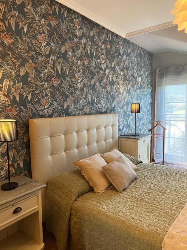 a bedroom with a bed and a wall with floral wallpaper at Costa Reinante Spa in Barreiros