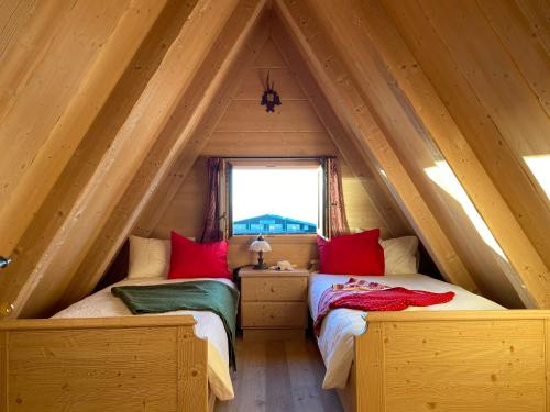 two beds in a room with a attic at Cozy Mountain Chalet in Cavalese