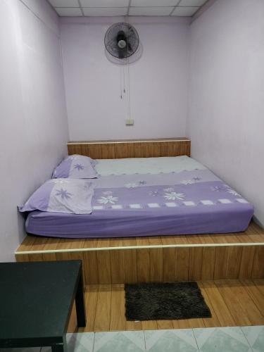 a bedroom with a bed and a fan on the wall at Canaan in Kanchanaburi
