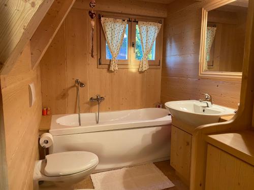 une salle de bain avec toilettes, baignoire et lavabo dans l'établissement Cozy Mountain Chalet, à Cavalese