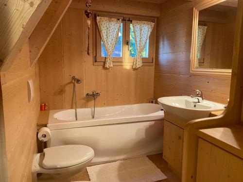 a bathroom with a toilet and a tub and a sink at Cozy Mountain Chalet in Cavalese