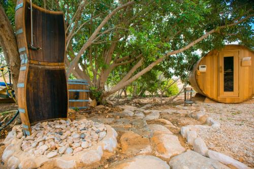 a building with a tree and a stone path at Carmey Avdat Farm in Midreshet Ben Gurion