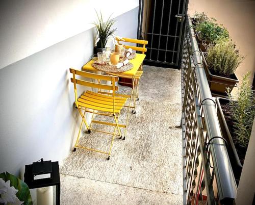 een gele tafel en stoelen op een balkon bij Casa Mia Maria Margot LODI Self check in in Lodi